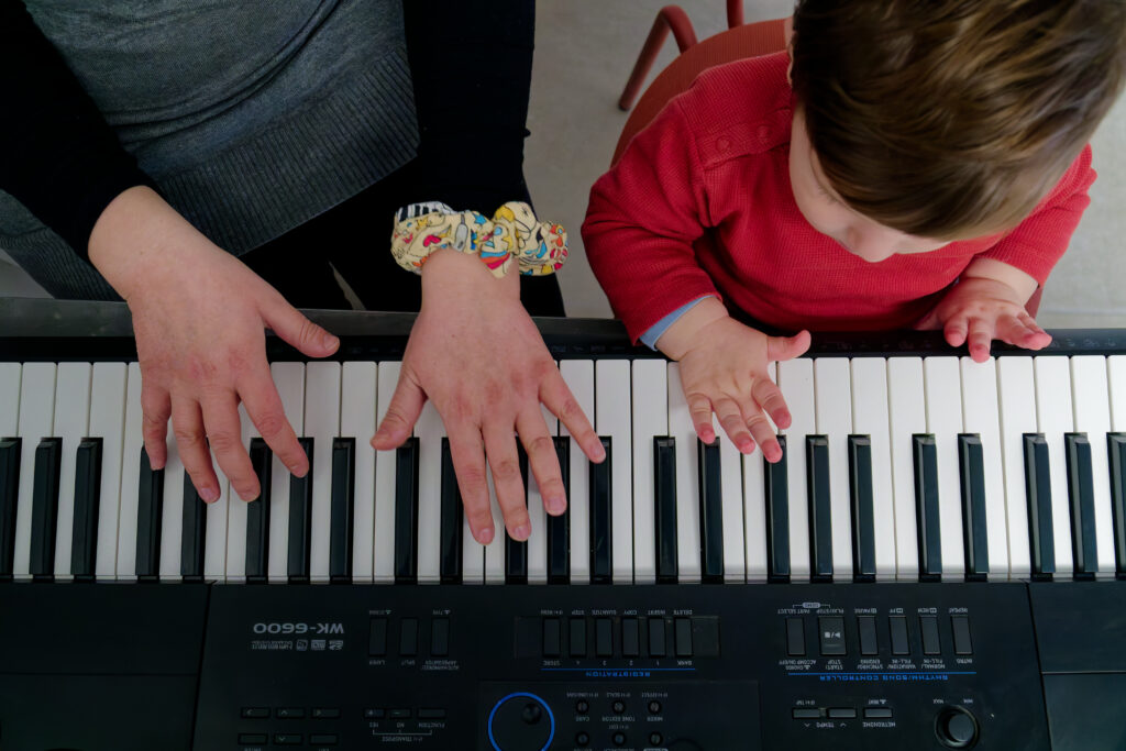 ενήλικα και παιδιά χέρια παίζουν πιάνο μαζί